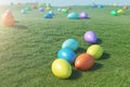 Colorful eggs in a meadow on a sunny day against the blue sky. Multicolored painted easter eggs on grass, lawn. Concept