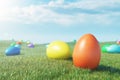 Colorful eggs in a meadow on a sunny day against the blue sky. Multicolored painted easter eggs on grass, lawn. Concept