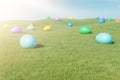 Colorful eggs in a meadow on a sunny day against the blue sky. Multicolored painted easter eggs on grass, lawn. Concept