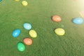 Colorful eggs in a meadow on a sunny day, top view. Multicolored painted easter eggs on grass, lawn. Concept easter eggs