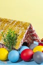 Colorful eggs symbolizing easter, with a toy house, flowers like a garden