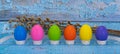 Colorful eggs tied with a festive ribbon and pussy willow on a blue wooden background. concept of celebrating Easter Royalty Free Stock Photo
