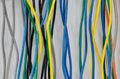 Colorful electrical cables hanging on a wall vertically. Royalty Free Stock Photo