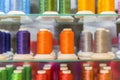 Colorful embroidery thread spool using in garment industry, row of multicolored yarn rolls, sewing material selling in the market.