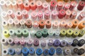 Colorful embroidery thread spool using in garment industry, row of multicolored yarn rolls, sewing material selling in the market