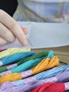 Colorful embroidery threads and hands preparing for stitching in a creative workspace concept Royalty Free Stock Photo