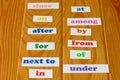 Colorful English preposition cards on wooden table