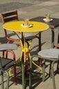 Colorful ensemble of vintage or grunge seating with round and square metal tables and metal chairs in the pedestrian zone Royalty Free Stock Photo