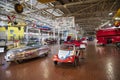 Colorful exotic cars and small airplanes hanging from the ceiling at Lane Motor Museum