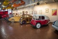 Colorful exotic cars and small airplanes hanging from the ceiling at Lane Motor Museum
