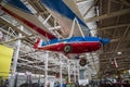 Colorful exotic cars and small airplanes hanging from the ceiling at Lane Motor Museum