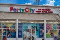 The colorful exterior facade of a Party City Discount Party Super Store on a clear, sunny day