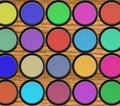 Colorful eyeshadows in black boxes over wooden table Royalty Free Stock Photo