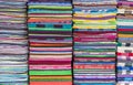 Colorful fabric and bath towels stacked in rows, pattern background.