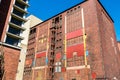 Colorful facade of old abandoned industrial ruin. Sealed windows, doors.