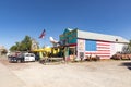 Colorful facade of Shop Historic Seligman Sundries with stars and stripes and an aircraft crashed in the facade and vintage car at