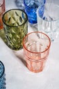 Colorful faceted and geometric drink glass, group of empty green, red, blue and transparent drinkware Royalty Free Stock Photo