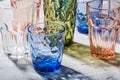 Colorful faceted and geometric drink glass, group of empty green, red, blue and transparent drinkware for beverage Royalty Free Stock Photo