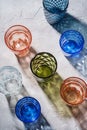 Colorful faceted and geometric drink glass, group of empty green, red, blue and transparent drinkware for beverage Royalty Free Stock Photo