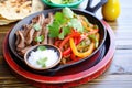 colorful fajita platter with sizzling beef, peppers, and onions