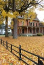 Colorful Fall image with golden leaves all over the ground outside and black wrought iron fence near church, Saratoga Springs, 201 Royalty Free Stock Photo