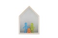 Colorful family figurines in wooden house on white background