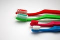 Colorful family toothbrushes on white background, red and green adult toothbrushes and pink and blue little two for children