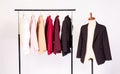 Colorful fashionable business suits hanging on rack for sale in store in white isolated background with mannequin dummy.