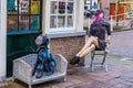 Colorful female and dog lay figures sitting on corner of a street