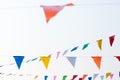 Colorful festive bunting flags against a blue sky and clouds background Royalty Free Stock Photo