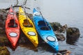 Colorful fiberglass kayaks lying on the rocky shore01