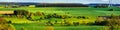 Colorful fields in belgian countryside panoramic view with windmill on horizon Royalty Free Stock Photo