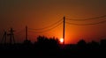 Colorful Fiery Red Sunset And Solar Pillar Effect. View Of Power Lines And Wires At Sunset