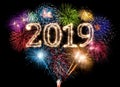 colorful fireworks display and bright sparkler pyrotechnic number 2019 happy new year background Royalty Free Stock Photo