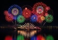 Colorful fireworks explode over a calm body of water, casting vivid Royalty Free Stock Photo