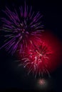 Colorful fireworks exploding in the night sky with vibrant red and purple hues Royalty Free Stock Photo