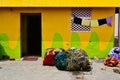 Colorful fisherman house with yellow walls and heap of fishermen nets Royalty Free Stock Photo