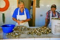 Colorful Fisherman Shucks Mussels in Chilean Fish Market