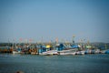 Colorful fishing boats with blue and white hulls and Indian flags on the masts, on the fishing pier in Goa. Wooden boats