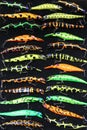 Colorful fishing lures on black background. Wide assortment of fishing devices