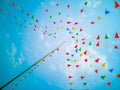 Colorful flags, colorful party decorations, small triangular flags to celebrate the party with the blue sky and clouds as the