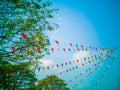 Colorful flags, colorful party decorations, small triangular flags to celebrate the party with the blue sky and clouds as the Royalty Free Stock Photo