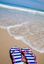 Colorful flip-flop sandals on sea beach Royalty Free Stock Photo