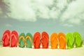 Colorful flip flop on sandy beach, green sea and blue sky Royalty Free Stock Photo