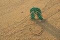 Colorful flip flops and smile icon on white sand beach Royalty Free Stock Photo