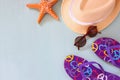 Colorful flip flops, starfish, shells, fedora hat and sunglasses on wooden background Royalty Free Stock Photo