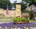 Colorful flower garden and American Flag at entrance to neighborhood in Frisco, Texas. Royalty Free Stock Photo