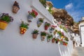 Colorful flower pots and rock overhangs - Setenil de las Bodegas, Andalusia, Spain