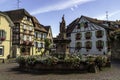 Colorful and flowery facade with village fountain in Eguisheim, Alsace, France Royalty Free Stock Photo