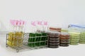 Colorful fluid culture medium in petri dish and test tube glassware with growing cultures of microorganisms on the table,